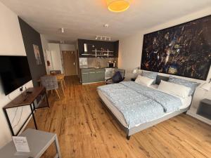 a bedroom with a large bed and a kitchen at Maxim City Apartment in Mainz