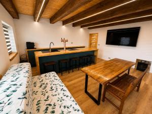 a living room with a wooden table and a kitchen at Wellness chalupa in Havlíčkŭv Brod