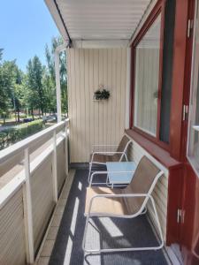 a porch with two chairs and a table on it at Rauhallinen majoitus parvekkeella in Joensuu