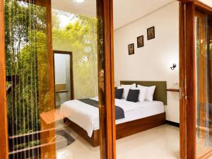 a bedroom with a bed and a sliding glass door at Tegal Luwih Cabin in Munduk