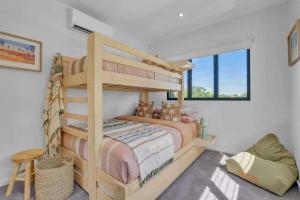 a bedroom with a bunk bed and a chair at Jila Cable Beach in Cable Beach