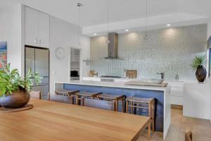 a kitchen with a wooden table and a blue counter at Jila Cable Beach in Cable Beach