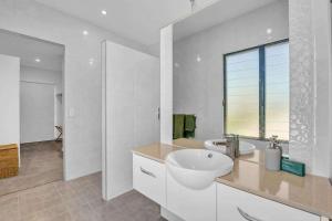 a white bathroom with a sink and a window at Jila Cable Beach in Cable Beach