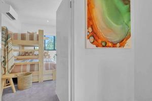 a bedroom with a bed and a painting on the wall at Jila Cable Beach in Cable Beach +12 photos