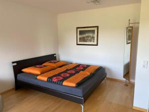 a bedroom with a bed with an orange blanket at Kornblick in Korntal-Münchingen