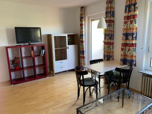 a living room with a table and chairs and a television at Kornblick in Korntal-Münchingen