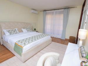 a bedroom with a large bed and a large window at Eyesha Villa in Kampala