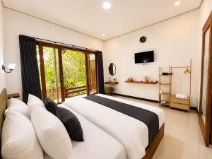 a bedroom with a large bed and a window at Tegal Luwih Cabin in Munduk