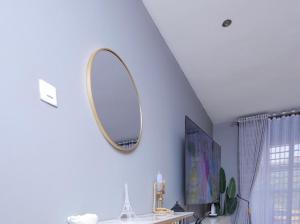 a mirror on a blue wall in a room at Eyesha Villa in Kampala