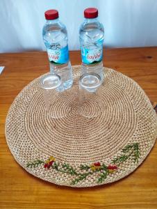 two bottles of water sitting on top of a plate at Les Jardins d'Areca in Antsirabe +5 photos