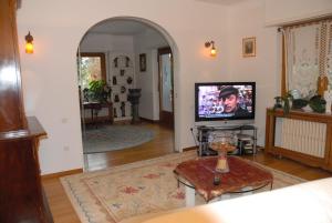 sala de estar con TV de pantalla plana y mesa en Villa Thalassa domaineleshesperides, en Bitche