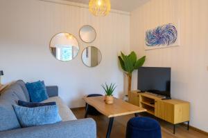 a living room with a blue couch and a tv at Apartment Mamma in Začretje