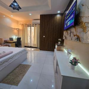 a bedroom with a bed and a television on a wall at Américain studio ngor almadies in Dakar