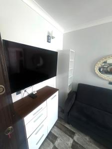 a living room with a black couch and a flat screen tv at Mira Residence in Bostancı