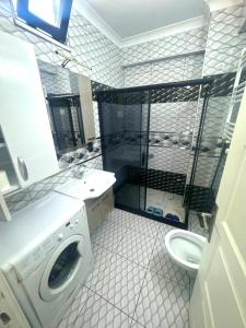 a bathroom with a washing machine and a sink at Mira Residence in Bostancı