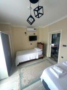 a bedroom with two beds and a flat screen tv at Mira Residence in Bostancı