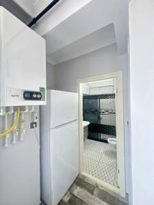 a kitchen with a refrigerator and a door to a bathroom at Mira Residence in Bostancı +3 photos