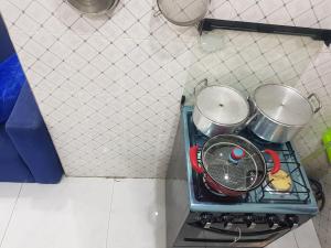 a stove with pots and pans on top of it at Américain studio ngor almadies in Dakar