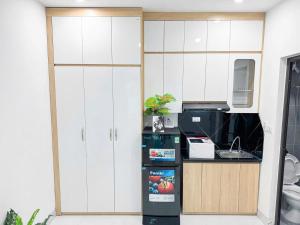 a kitchen with white cabinets and a refrigerator at Khach san Ngoc Ha in Ninh Binh