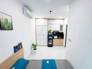 a white room with a bed and a kitchen at Khach san Ngoc Ha in Ninh Binh