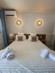 a bedroom with a large white bed with towels on it at Lou Cagnard in Saint-Tropez