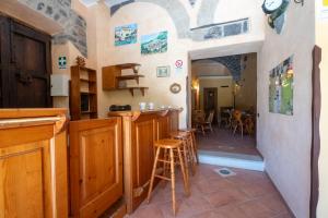a kitchen with a bar and stools in a room at Filohostel l'Albergo Glocale in Sant'Agata de' Goti