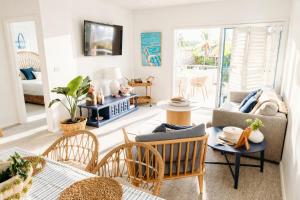 a living room with a couch and tables and chairs at Newly Restyled Resort 1 Bedroom Unit Oaks Pacific Blue in Salamander Bay