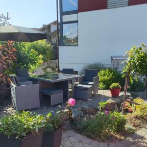 a patio with a table and chairs and flowers at Ferienwohnung Alpenglück hoch3 in Oy-Mittelberg