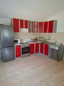 a kitchen with red cabinets and stainless steel appliances at Village house Tea in Virpazar