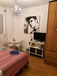 a bedroom with a bed and a tv and a table at SIDI & Bb in Casalecchio di Reno