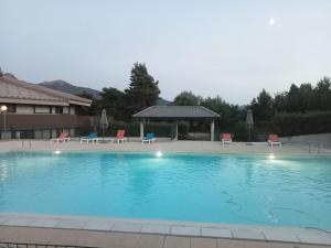 a large swimming pool with chairs and a gazebo at Résidence Serre-Ponçon in Chorges
