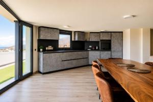 an open kitchen and dining room with a wooden table and chairs at Exceptional Villa With Pool in Villaverde