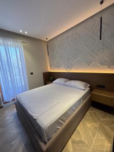 a bedroom with a large bed and a wall at Sulejmanasi Rooms in Vlorë