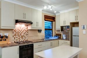 a kitchen with white cabinets and a white counter top at Drakensberg Vultures View in Cathkin Park