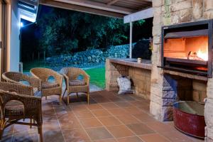 a patio with a fireplace with chairs and a table at Drakensberg Vultures View in Cathkin Park