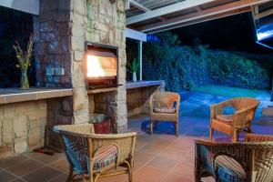 a patio with wicker chairs and a stone fireplace at Drakensberg Vultures View in Cathkin Park