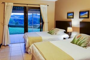 a hotel room with two beds and a window at Drakensberg Vultures View in Cathkin Park +62 photos