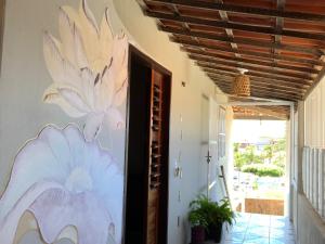 a painting of flowers on the wall of a hallway at hostel xamã in Flecheiras