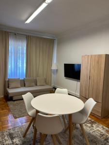 a living room with a table and chairs and a couch at ICOSIUM Hostel in Braga