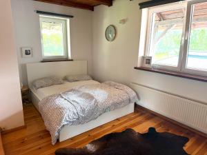a bedroom with a bed and two windows at Dom Szalkowo Jeziorak Pavillon in Szałkowo