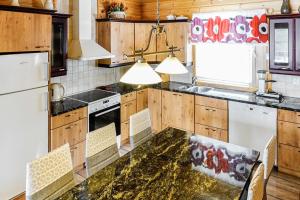 a kitchen with wooden cabinets and a marble counter top at Orrenkolo, Lapland in Luosto