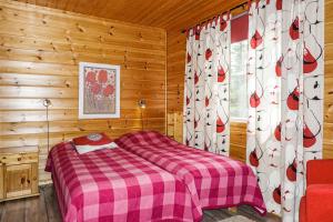 a bedroom with a bed and curtains in a cabin at Orrenkolo, Lapland in Luosto