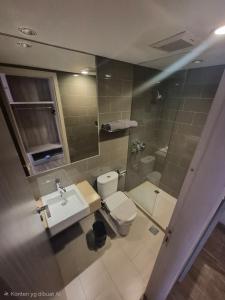 a bathroom with a toilet and a sink and a mirror at Expressia Hotel Makassar in Makassar +28 photos