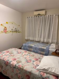 a bedroom with two beds and a window at Sítio das Flores muito espaço e aconchego para reunir família e amigos in Garibaldi