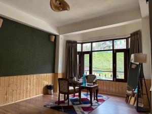 a room with a table and chairs and a window at Hotel Nivasa, Narkanda in Nārkanda