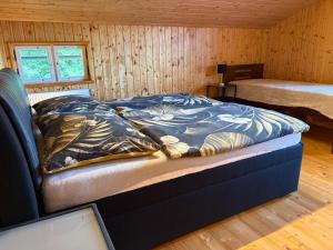 a bedroom with a bed in a wooden cabin at Chata Na Mechu in Dolní Podluží