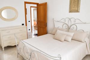 a white bedroom with a white bed and a mirror at Maridea - La Terrazza in Ponza +7 photos