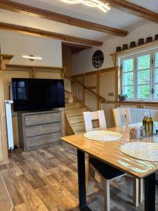 a dining room with a table and a television at Chata Na Mechu in Dolní Podluží