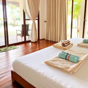 a bedroom with a bed with towels on it at Sunset Villas Palauig Zambales in Palauig +45 photos