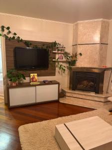 a living room with a tv and a fireplace at Sítio das Flores muito espaço e aconchego para reunir família e amigos in Garibaldi